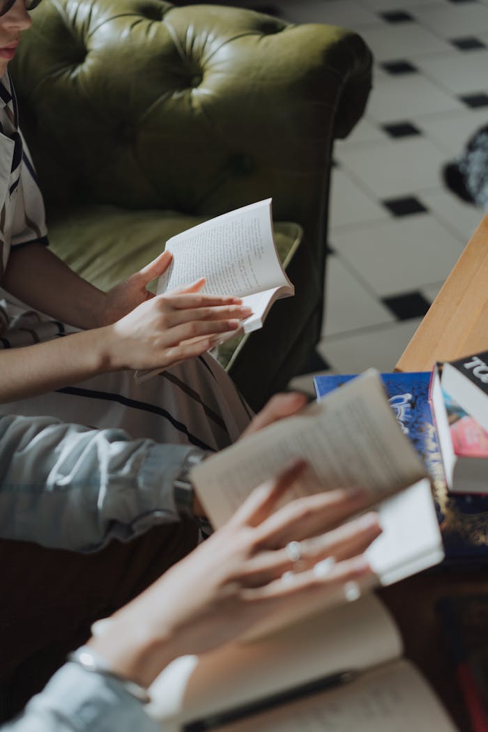 Hands holding books in a cozy library, great for leisure and education themes.